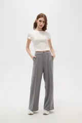 Pantalon de corte holgado y tiro alto, confeccionado en tejido de punto gris con costuras frontales verticales que simulan una tabla.