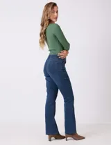 Jean de tiro alto con corte bootcut, ajustado en cadera y muslos con una sutil apertura desde la rodilla. Presenta diseño clásico de cinco bolsillos, cierre con botón y costuras en contraste. Su diseño posterior incluye costuras estratégicas para un efecto de realce en la silueta.
