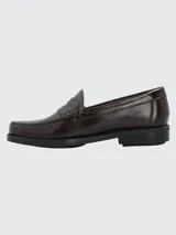 Zapato tipo mocasín de cuero color bordó con acabado brillante, diseño de antifaz clásico y suela de goma con tecnología de amortiguación.