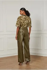 Pantalón cargo verde militar de efecto piel, con hebilla en la cintura, bolsillos laterales ocultos y bolsillos cargo.