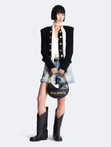 Bolso bandolera Balmain modelo Soft Moon, confeccionado en cuero negro con patrón geométrico en relieve y logo Balmain en letras doradas. Asa de cadena dorada con apliques de cuero negro.