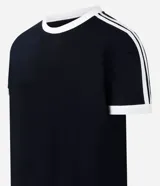 Remera de algodón color celeste con cuello redondo y bordes de mangas en color blanco. Presenta diseño de rayas dobles blancas en los hombros y mangas.