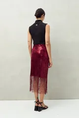 Falda larga negra de lentejuelas con terminación en flecos.