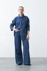 Jean wide leg de color negro con silueta amplia y caída fluida. Presenta detalles de tachas aplicadas que recorren el diseño en forma de ondas. Confeccionado en denim de algodón.