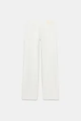 Jeans de mezclilla en color negro gastado, tiro bajo, corte de pernera recta y diseño clásico de cinco bolsillos con cierre frontal de cremallera y botón metálico.