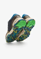 Championes urbanos Satorisan modelo Chacrona, confeccionados en cuero marrón con detalles en gamuza, cordones amarillos y suela de goma con efecto salpicado y detalles en verde.