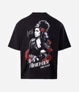 Remera boxy fit de algodón color negro, con cuello redondo y mangas cortas. Presenta un estampado de la cantante Amy Winehouse en blanco y negro con detalles en rojo, y la inscripción "Amy Winehouse Back to Black".