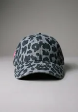 Gorra de béisbol con estampado animal print en tonos azules y grises, y bordado blanco en el frente. Cuenta con visera curva y ajuste regulable en la parte trasera.