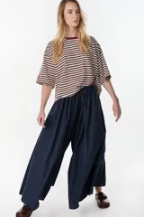 Pantalón largo color marrón, estilo wide leg, de tiro medio con cintura elástica fruncida y bolsillos laterales.