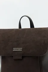 Mochila estructurada color marrón oscuro, con frente en acabado gamuzado y cuerpo en símil cuero texturizado. Tiene asa superior y correas regulables.