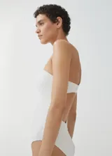Traje de baño enterizo color blanco con textura tipo waffle, diseño strapless con escote recto y espalda descubierta.