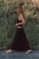 Falda midi negra de tejido satinado, corte recto y tiro alto con cintura elástica.