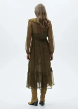 Vestido largo de tejido fluido semitransparente con estampado paisley en tonos verdes y marrones. Presenta cuello en pico con volantes, mangas largas con puños elásticos y cintura con cordón ajustable. Incluye forro interior y diseño evasé con bajo con vuelo.