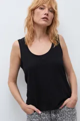 Musculosa blanca básica de corte recto, con escote redondo a la base y tirantes anchos.