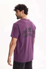 Remera de manga corta color violeta, con diseño semi boxy y estampa en la espalda con tres estrellas y la palabra "Infinity".