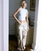 Musculosa blanca de algodón con lycra, corte cropped, cuello redondo y detalle fruncido con tiras para anudar en el hombro derecho.