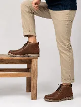 Bota de cuero genuino color marrón, con cordones frontales y suela resistente.