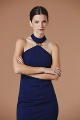 Vestido midi de mujer en crepé elastizado, de color azul marino, con escote halter y detalle metálico dorado en el cuello. Diseño ajustado que realza la silueta.