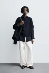 Camiseta de tejido de punto crochet con estructura abierta, color azul marino. Presenta cuello redondo y mangas cortas.