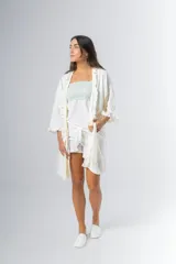 Bata kimono gris claro de algodón con volados en mangas y ruedo. Tiene mangas al codo y lazo de algodón para ajustar en la cintura.