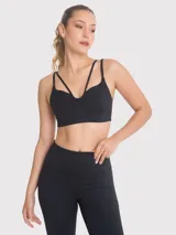 Top deportivo negro con diseño de tiras cruzadas en el frente, escote redondeado y banda elástica inferior para mayor soporte.
