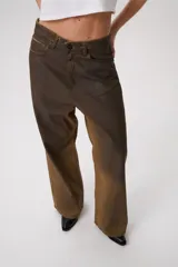 Jean baggy de tiro medio con efecto desgastado y acabado degradé en tonos tierra. Silueta amplia y recta en denim tratado a mano.