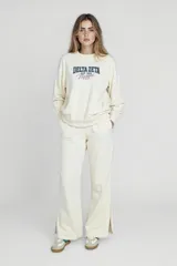 Pantalón de tiro alto color crema, con tajo en el costado y pierna ancha.