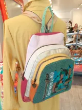 Mochila de cuero multicolor con diseño artístico pintado a mano, múltiples compartimentos con cierre y herrajes metálicos.