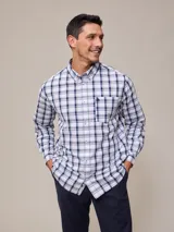Camisa de manga larga para hombre con estampado a cuadros en tonos blanco, azul marino y verde claro. Presenta cuello abotonado (button-down) y un bolsillo en el pecho con un pequeño logo bordado.