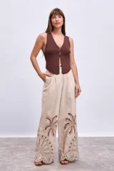 Chaleco de tejido de punto acanalado color marrón oscuro, con escote en V y cierre frontal de botones dorados.