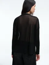 Sweater de tejido fino y semitransparente con hilo brillante. Presenta cuello redondo, hombros caídos y mangas largas amplias con un ajuste relajado y caída fluida.