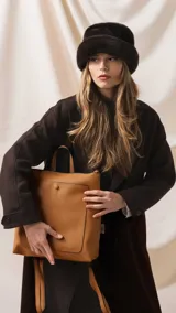 Mochila de diseño moderno y funcional, confeccionada en símil cuero con textura granulada. Cuenta con un bolsillo frontal con broche, cierre principal superior, manija superior y correas ajustables. Incluye logo de la marca grabado en el frente.