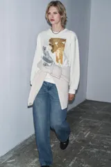Sudadera de cuello redondo y manga larga, con diseño de estampado artístico metalizado en tonos dorados y plateados en el frente. Presenta acabados en rib en cuello, puños y ruedo.