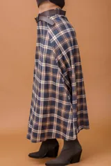 Falda midi de corte recto con estampado escocés en tonos chocolate, azul y beige. Presenta un diseño clásico con cintura alta y caída fluida.