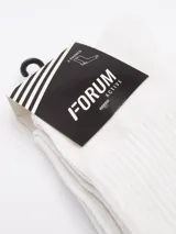 Pack de dos pares de medias deportivas largas, color blanco, con tejido acanalado y logo pequeño de la marca en tono gris oscuro en la zona del tobillo.