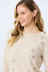Buzo tejido de algodón color beige con cuello redondo, manga larga y delicados detalles bordados de flores.