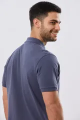 Remera polo de piqué de algodón color azul, de manga corta, con cuello camisero, cierre frontal de dos botones y pequeño logo bordado en el pecho.