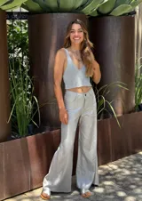 Pantalón de tiro alto color plateado metalizado, de corte recto y holgado, con cierre frontal de botón y cremallera.