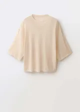 Jersey de punto fino en color beige, con diseño oversize, cuello redondo y mangas tres cuartos.