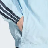 Campera deportiva Adidas con cierre frontal, cuello alto y bolsillos laterales. Diseño en color celeste con las icónicas tres rayas de la marca en color azul marino a lo largo de las mangas y logo bordado en el pecho.