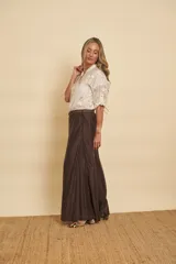 Camisa blanca de cuello mao, manga larga con presilla para arremangar, cierre frontal con botones y delicados bordados florales en tono sobre tono.
