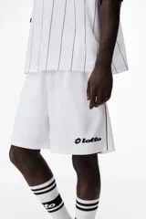 Short de fútbol blanco en malla, modelo de corte relajado con cintura elástica ajustable mediante cordón, bolsillos laterales y líneas negras decorativas en los laterales. Cuenta con el logo de Lotto estampado en contraste en una pierna.