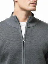 Campera tejida de punto con cierre frontal completo, cuello medio y dos bolsillos laterales abiertos. Presenta un diseño de textura en relieve y puños acanalados.
