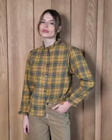 Camisa de algodón con estampado de rayas verticales finas, cuello alto con volados, cierre frontal con botones dobles y mangas largas con puños elásticos terminados en volados.