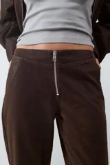 Pantalón de tiro medio con acabado efecto ante, diseño de pierna recta, con bolsillos laterales y traseros, y cierre frontal con cremallera metálica.