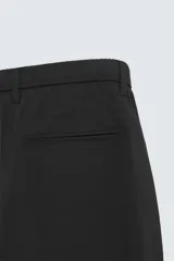 Pantalón de corte slim fit confeccionado en tejido elástico, con cintura elástica, cierre frontal con cremallera y botón, bolsillos laterales y bolsillos traseros de vivo.