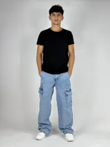 Pantalón de jean celeste con lavado ácido, corte ancho (baggy) y múltiples bolsillos cargo.