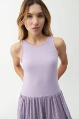 Vestido largo color salmón, con cuerpo ajustado de algodón y falda amplia de rayon, nylon, poliéster y elastano. Presenta un volante plisado en diagonal desde el hombro hasta la cintura.