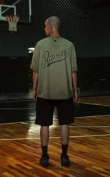 Remera de manga corta, cuello redondo y calce oversize, color verde militar con efecto batik artesanal. Presenta un parche o estampado en el pecho con el número "90".