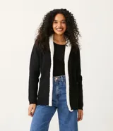 Cárdigan negro de tejido de punto con ribete de piel sintética blanca en el cuello, el frente y los bolsillos.